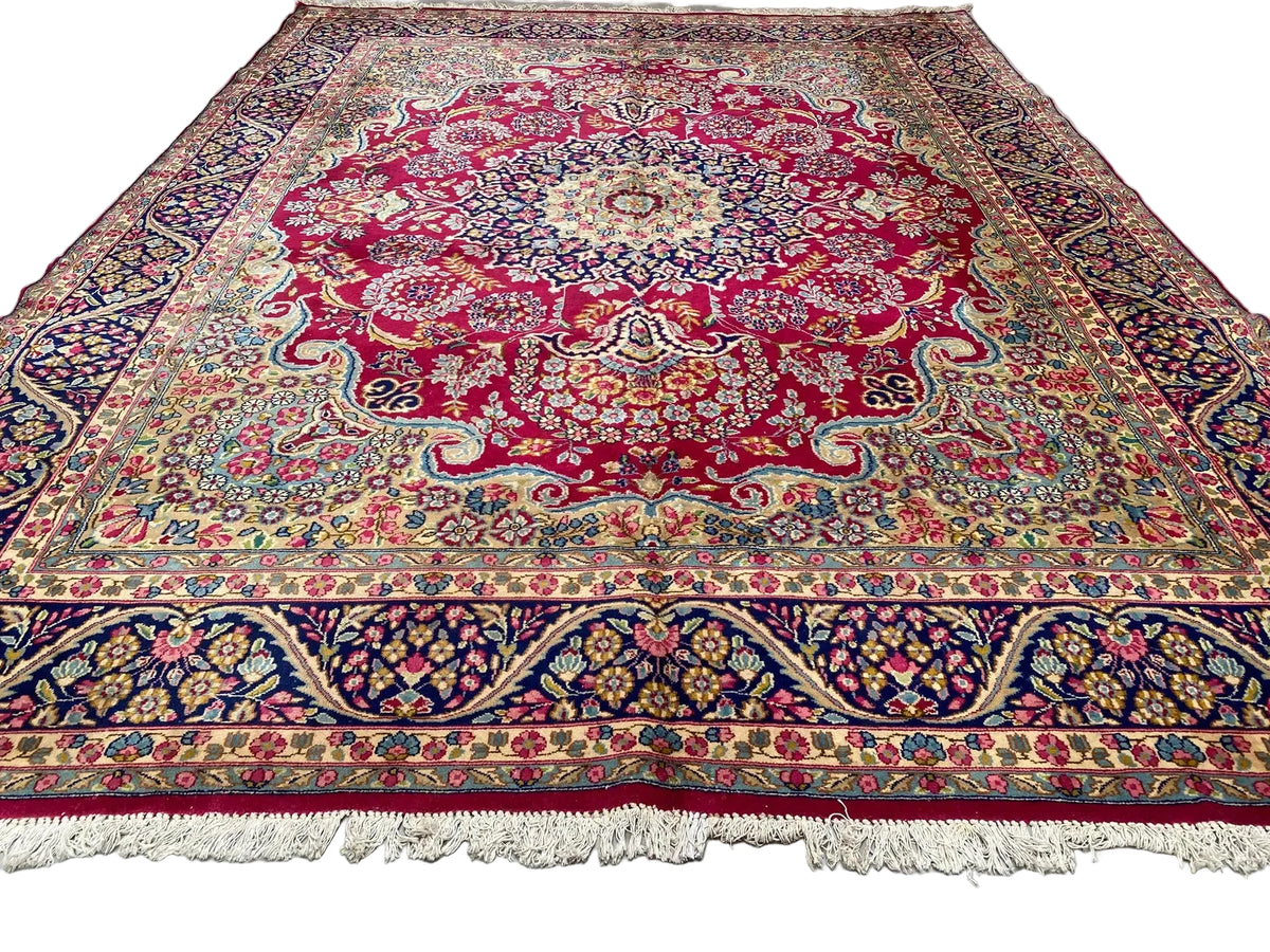 Large ruby-red Persian-style Oriental rug measuring 267 x 345 cm, featuring an intricate floral medallion, ivory botanical patterns and navy decorative borders.